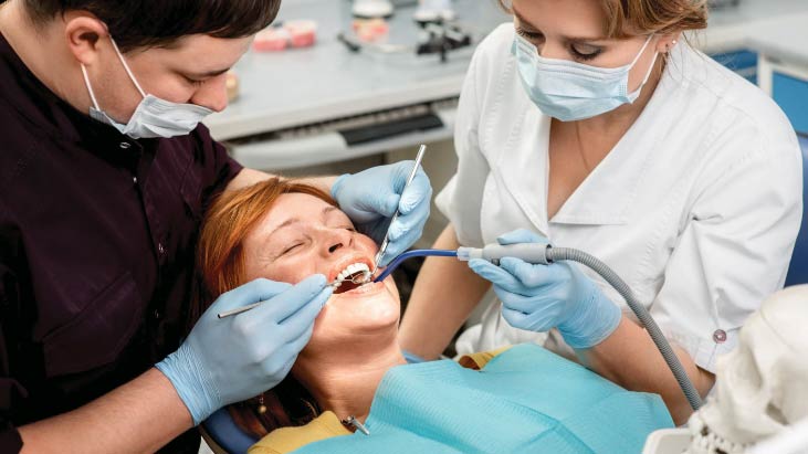 mature-woman-laying-down-in-dental-chair-during-dental-exam